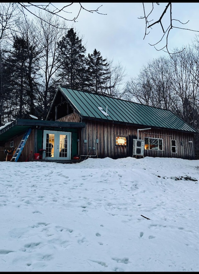 snow covered structure featuring french doors