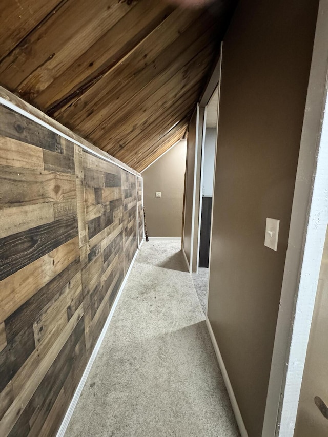 corridor with lofted ceiling, wood ceiling, and light carpet