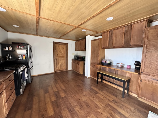 kitchen with dark countertops, wooden ceiling, dark wood-style floors, stainless steel range with gas stovetop, and recessed lighting