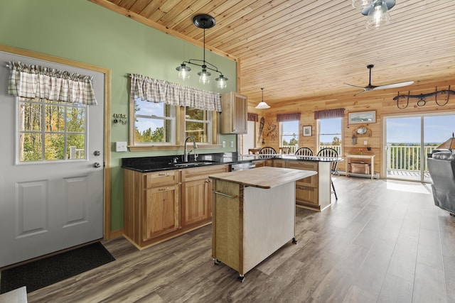 kitchen featuring kitchen peninsula, wooden walls, sink, pendant lighting, and wooden ceiling