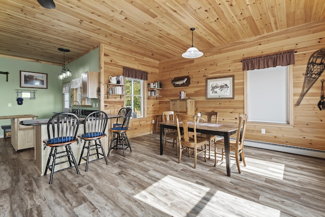 dining space featuring an inviting chandelier, wooden ceiling, wooden walls, and light hardwood / wood-style flooring