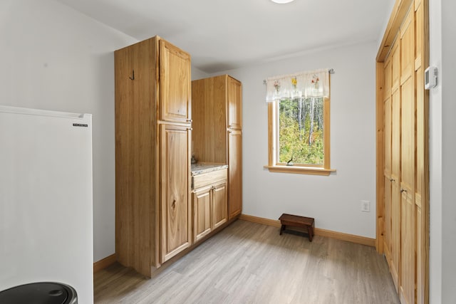 interior space with white fridge and light wood-type flooring