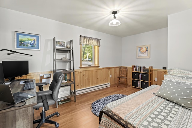 bedroom with wood-type flooring and a baseboard heating unit