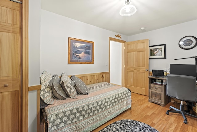 bedroom with hardwood / wood-style flooring and wood walls