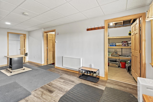 interior space with radiator heating unit, light wood-type flooring, and a paneled ceiling