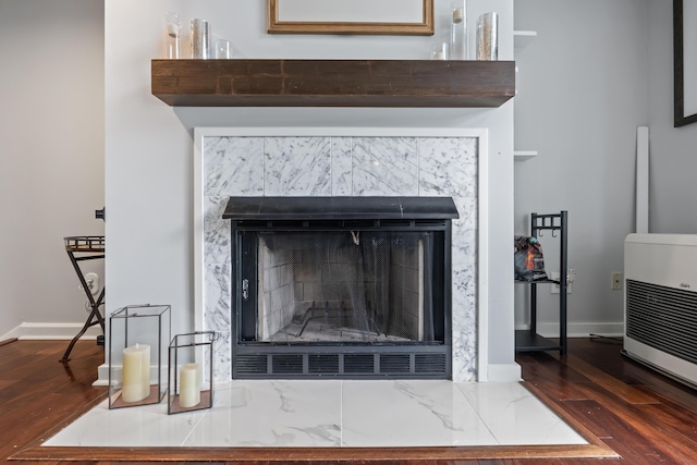 interior details featuring heating unit and hardwood / wood-style floors