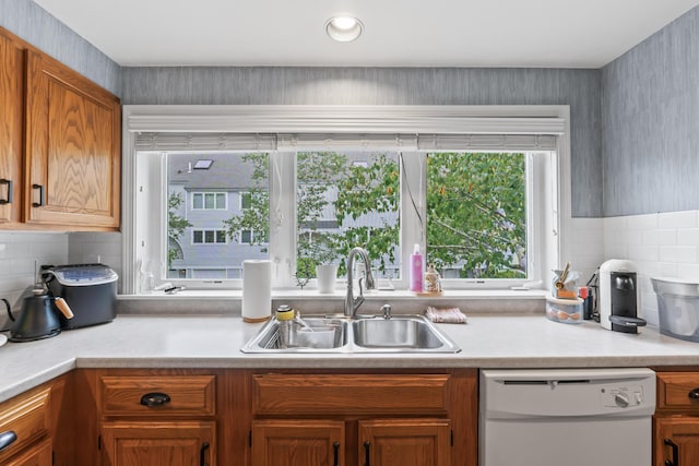 kitchen featuring decorative backsplash, sink, and white dishwasher