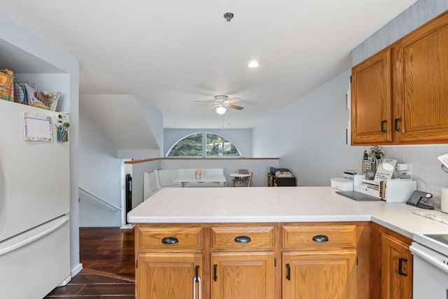 kitchen with kitchen peninsula, tasteful backsplash, ceiling fan, range, and white fridge