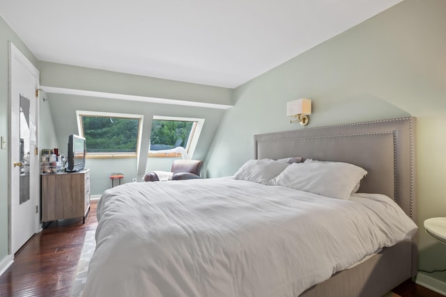 bedroom with dark hardwood / wood-style floors and a skylight