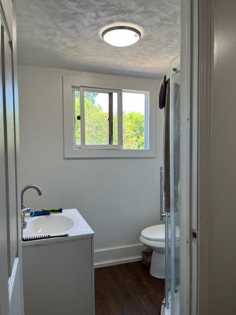 bathroom with vanity, wood-type flooring, an enclosed shower, and toilet