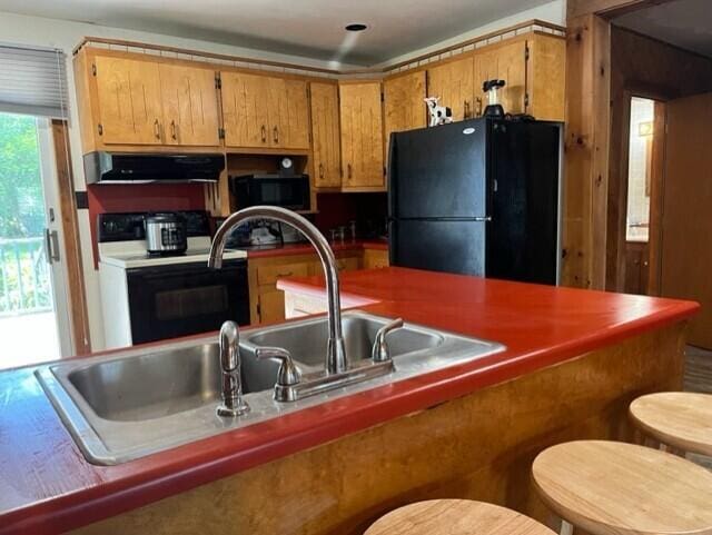 kitchen with ventilation hood and black appliances