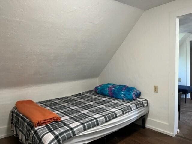 bedroom featuring vaulted ceiling and dark hardwood / wood-style floors