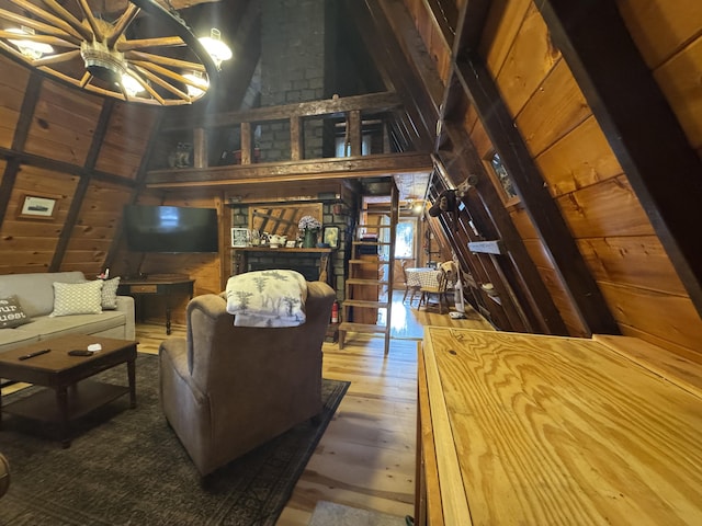 living room featuring ceiling fan, wood-type flooring, wooden ceiling, vaulted ceiling with beams, and wood walls