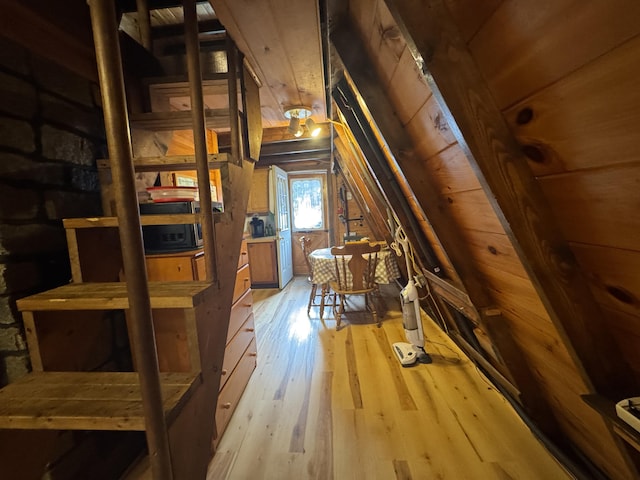 additional living space featuring wood walls, wood ceiling, vaulted ceiling, and light wood-type flooring