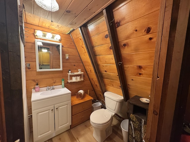 bathroom with hardwood / wood-style floors, lofted ceiling, wooden walls, vanity, and wood ceiling