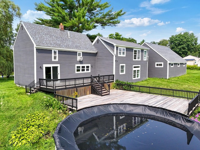 back of property featuring a lawn and a pool side deck