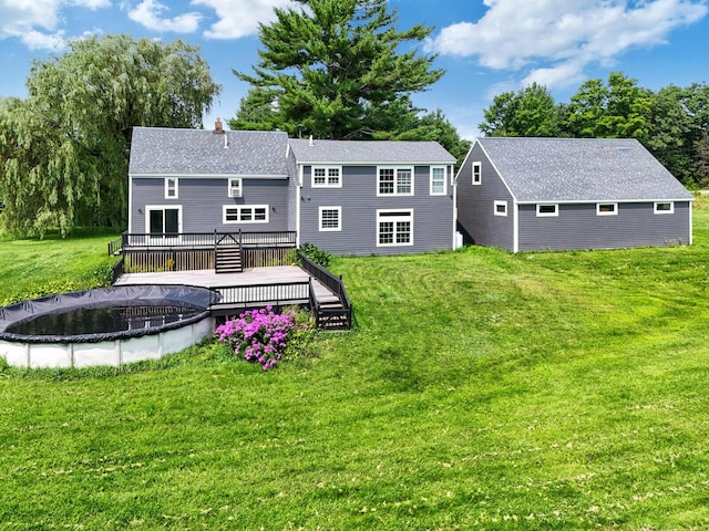 back of property with a lawn and a wooden deck