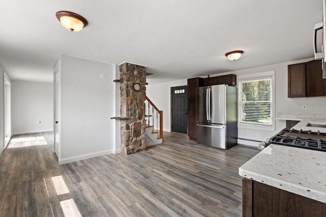 kitchen featuring dark brown cabinets, stainless steel refrigerator, dark wood-type flooring, and range