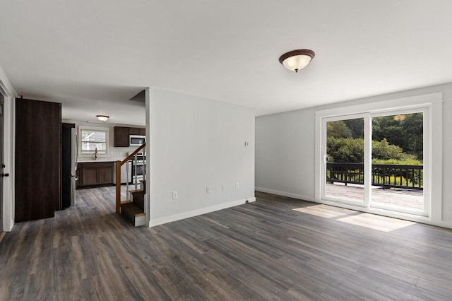 spare room with dark hardwood / wood-style floors, plenty of natural light, and sink