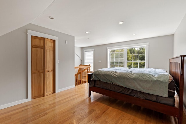 bedroom featuring light hardwood / wood-style flooring and lofted ceiling