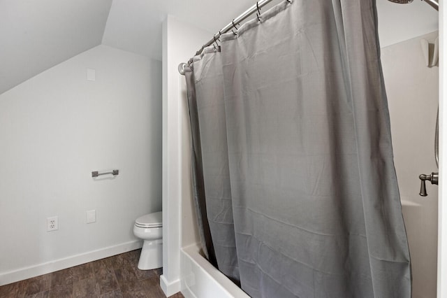 bathroom with toilet, hardwood / wood-style flooring, vaulted ceiling, and shower / tub combo with curtain