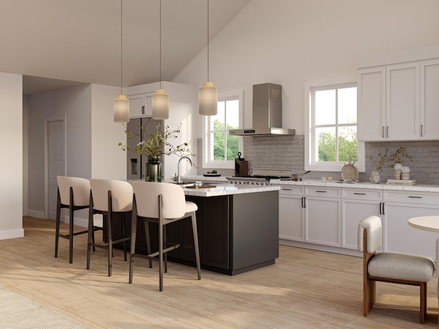 kitchen featuring backsplash, white cabinets, wall chimney exhaust hood, decorative light fixtures, and a kitchen island