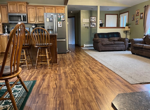 kitchen with dark hardwood / wood-style floors, baseboard heating, and appliances with stainless steel finishes