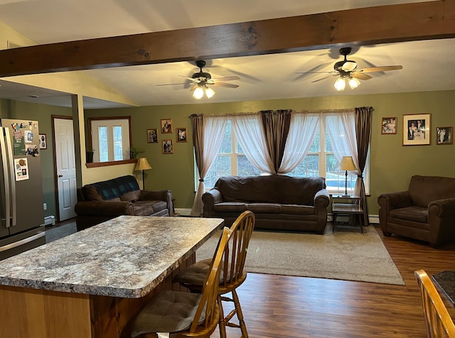 dining room with lofted ceiling with beams, ceiling fan, baseboard heating, and dark wood-type flooring