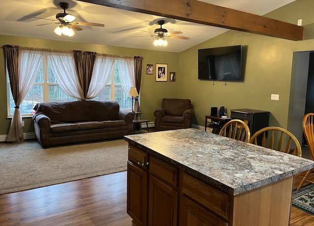 kitchen with hardwood / wood-style floors, lofted ceiling with beams, a center island, and ceiling fan