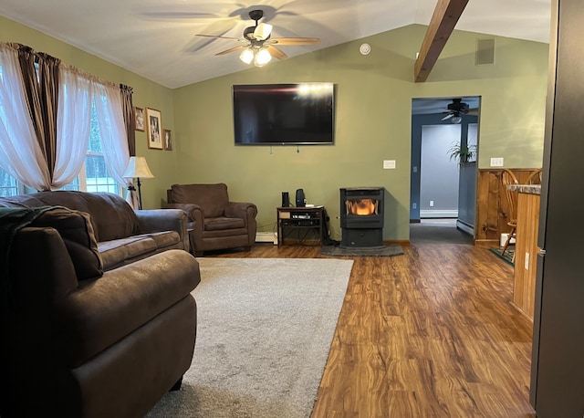 living room with dark hardwood / wood-style flooring, lofted ceiling with beams, a wood stove, and ceiling fan