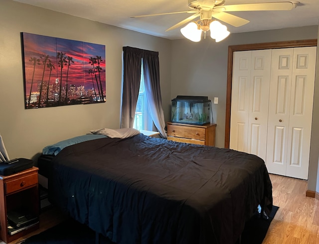 bedroom with a closet, light hardwood / wood-style flooring, and ceiling fan