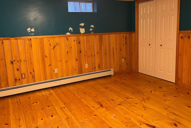 unfurnished room featuring light hardwood / wood-style flooring and a baseboard radiator