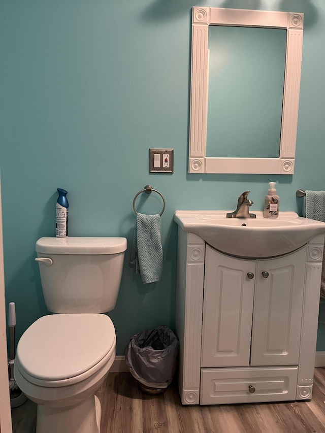 bathroom with hardwood / wood-style flooring, vanity, and toilet