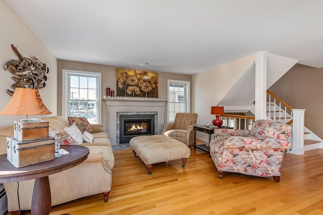 living room featuring a premium fireplace and light hardwood / wood-style flooring