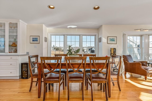 dining area with light wood-type flooring and wine cooler