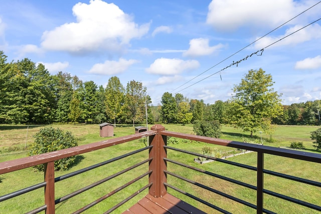 view of gate with a lawn and a storage shed