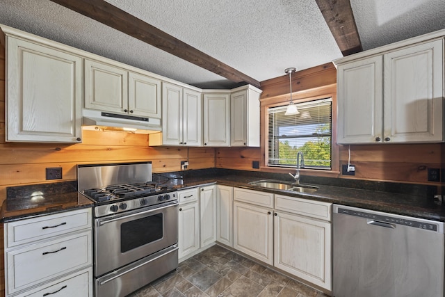 kitchen with beam ceiling, wooden walls, sink, and stainless steel appliances