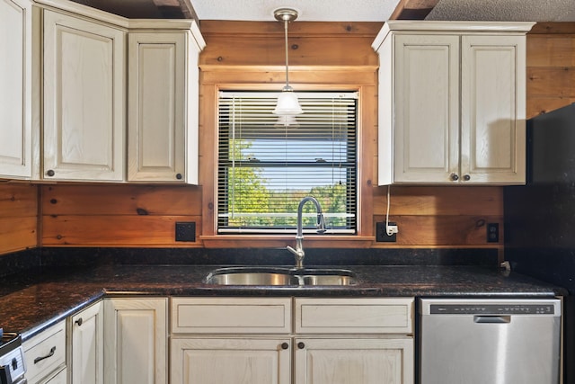 kitchen featuring sink, stainless steel dishwasher, dark stone counters, and wood walls