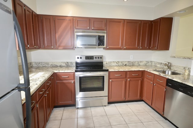 kitchen with light tile patterned flooring, sink, light stone countertops, and stainless steel appliances