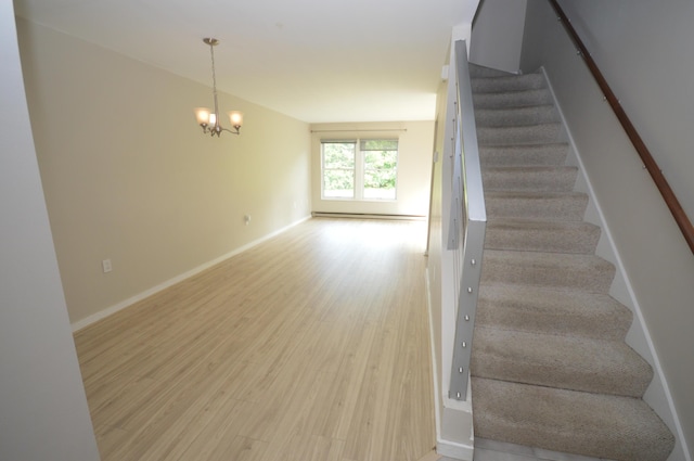 staircase featuring hardwood / wood-style floors and a notable chandelier