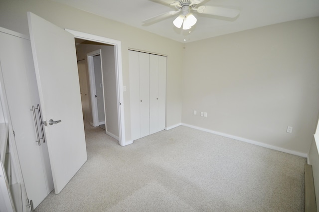 unfurnished bedroom with ceiling fan, light colored carpet, and a closet