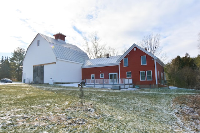 back of property with a yard and a deck