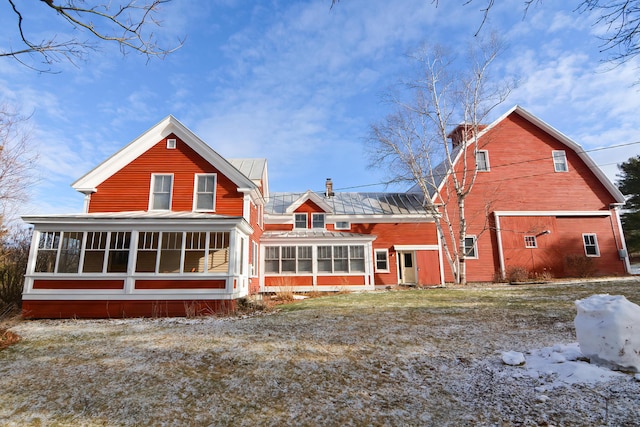 snow covered property featuring a sunroom