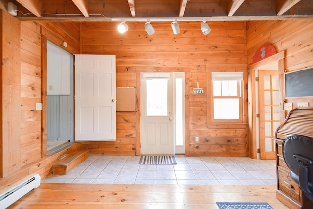 foyer entrance with track lighting, wooden walls, a baseboard radiator, and light tile patterned floors