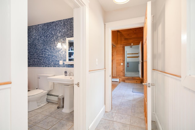 bathroom featuring toilet, wooden walls, tile patterned flooring, and a baseboard heating unit