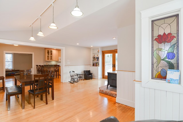 dining room featuring light hardwood / wood-style flooring, vaulted ceiling, and plenty of natural light