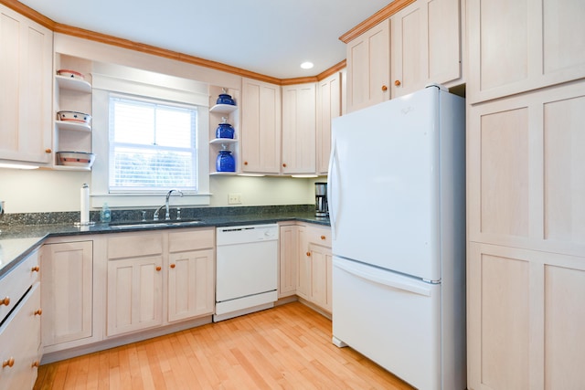 kitchen featuring white appliances, light hardwood / wood-style flooring, dark stone countertops, and sink