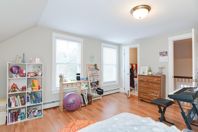 workout room featuring baseboard heating, hardwood / wood-style floors, and lofted ceiling