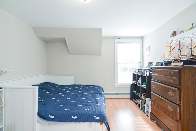 bedroom featuring baseboard heating and hardwood / wood-style flooring