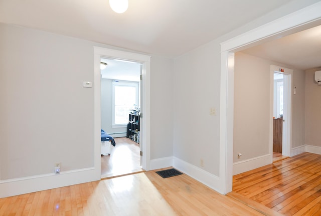 corridor featuring hardwood / wood-style floors and a baseboard heating unit